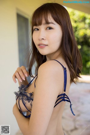 A woman in a pink thong is posing for the camera.