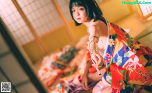 A naked asian woman standing in front of a window.