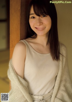 A woman in a white sweater posing for a magazine.