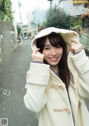 A woman in a white sweater is smiling at the camera.