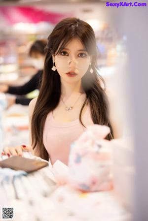 A woman sitting at a table in a store.