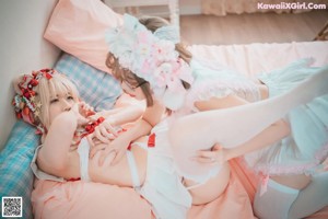 Two young women dressed in white and pink are posing for a picture.