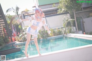 A woman in a bunny costume floating in a pool.
