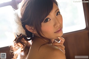 A woman laying on top of a bed with a flower in her hair.