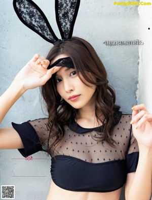 A woman wearing bunny ears and a black top.