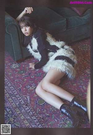 A woman laying on a rug with her legs crossed.