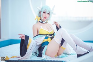 A woman in a yellow and white outfit holding a sword.