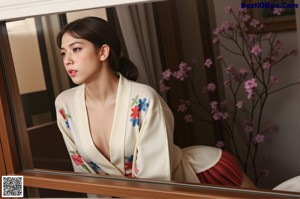 A naked asian woman in a yellow kimono posing for the camera.