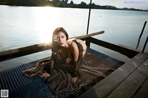 A woman in a black lingerie sitting on a boat.