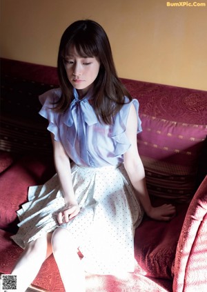 A woman in a white bra laying on a bed.