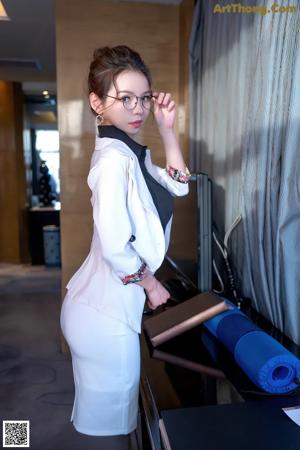 A woman in a black lingerie sitting on a table.