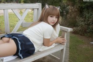 A woman in a pink bikini sitting on a wooden bench.
