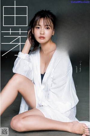 A woman in a white shirt is posing for a magazine.