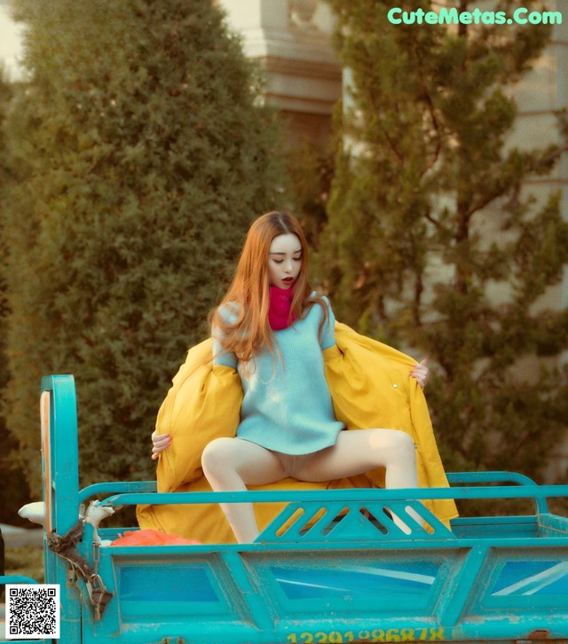 A woman sitting on top of a blue truck.