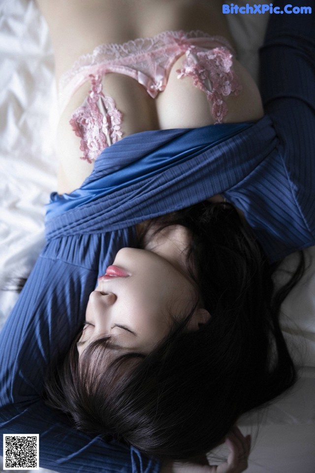 A woman laying on a bed with her eyes closed.