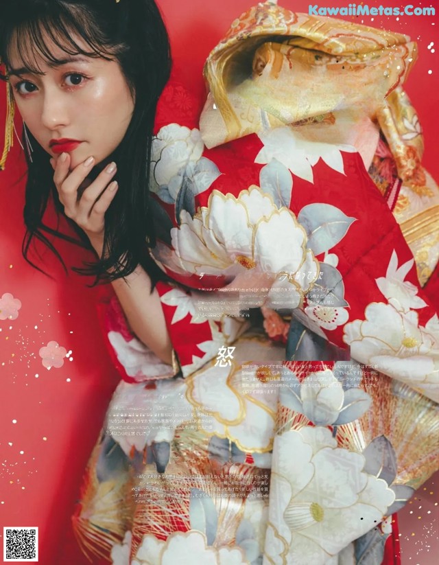 A woman in a red and white kimono posing for a magazine.