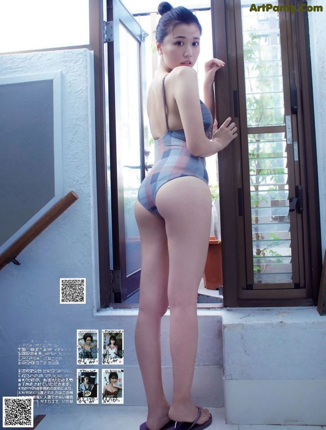 A woman in a bathing suit standing in front of a door.