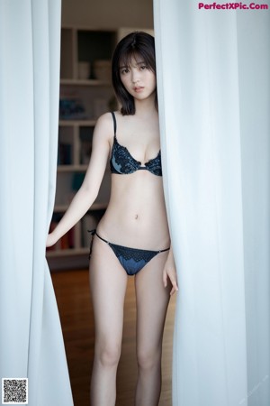 A woman in a black and blue lingerie laying on the ground.