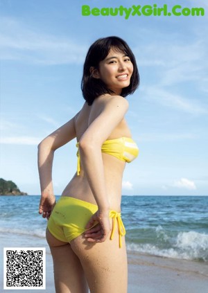 A woman in a blue bikini laying on the edge of a pool.