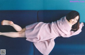 A woman in a pink sweater is posing for a magazine.