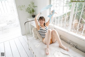 A woman laying on a bed in a bikini and stockings.