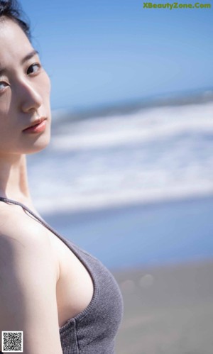 A close up of a woman's face on the beach.