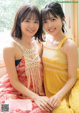 A couple of women standing next to each other on a beach.