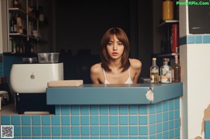 A woman in a blue shirt and white panties sitting on a chair.