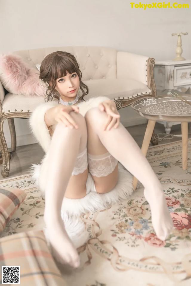 A woman sitting on a couch wearing white stockings.