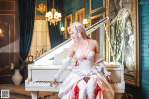 A woman in a white dress playing a piano.