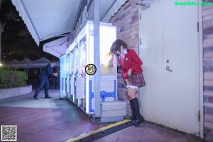 A woman standing in front of a video game machine.