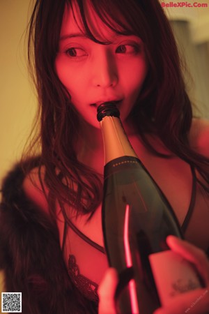 A woman in a purple fur coat with her hand on her chin.